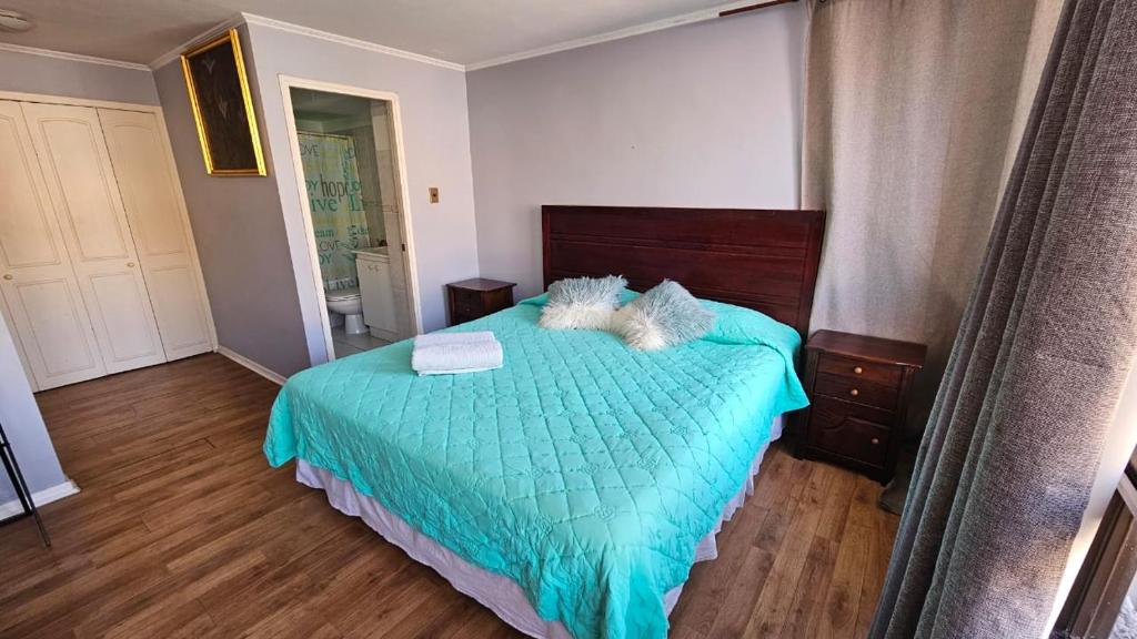 a bedroom with a bed with a blue comforter at Departamento en Playa Brava Iquique 1 dormitorio 1 baño in Iquique