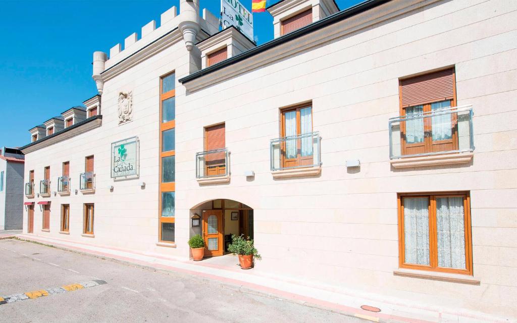 a white building with windows and a door at Hospederia La Cañada in Moralzarzal