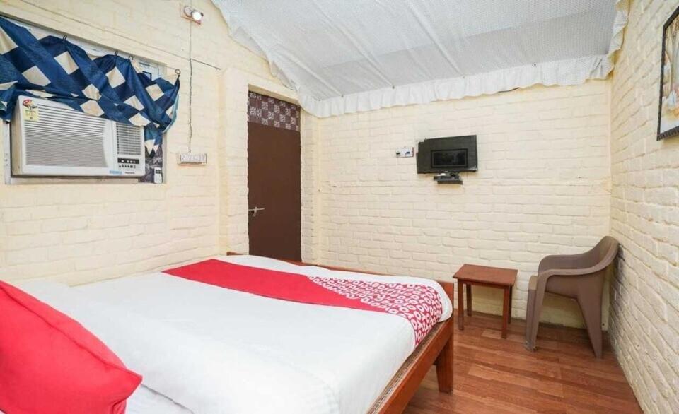 een kleine kamer met een bed en een kleine tafel bij OYO Flagship RS Woods in Pushkar