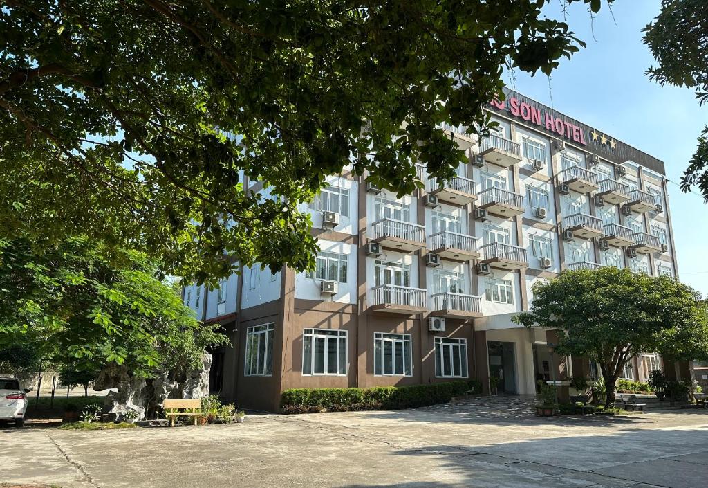 a building in front of a parking lot at Bao Son Hotel in Ninh Lão