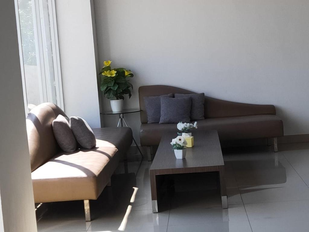 uma sala de estar com um sofá e uma mesa de centro em Apartemen Skylounge Makassar em Manda
