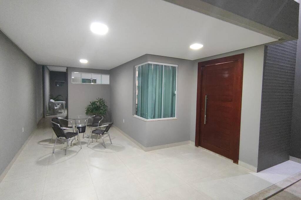 uma sala de jantar com uma mesa e cadeiras e uma porta em Casa TOP 1 Suite e 2 Quartos todos com Ar Condicionado em Guanambi
