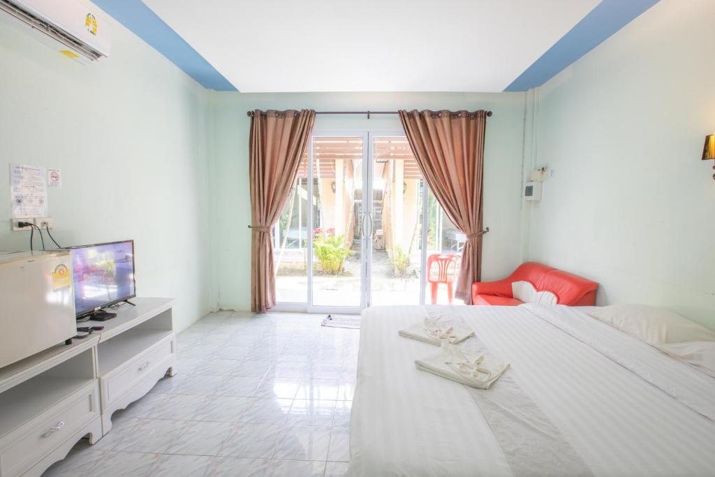 1 dormitorio con 1 cama, TV y sofá en Best House Resort, en Ban Pak Ba Ra