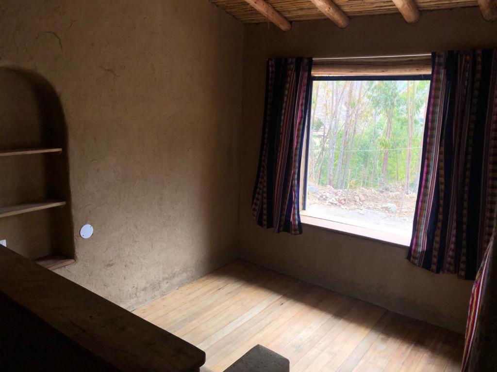 ein leeres Zimmer mit einem Fenster und einem Holzboden in der Unterkunft Casa Martha in Pisac