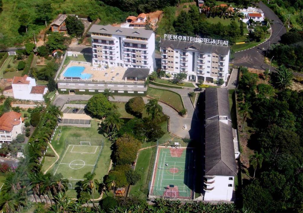 an aerial view of a building with a tennis court at Piemonte Flat Hotel in Serra Negra