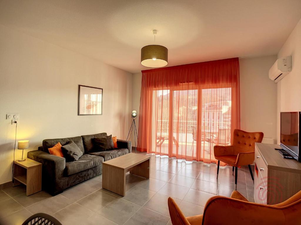 un salon avec un canapé et une table dans l'établissement Appartement F2 climatisé avec parking, Wi-Fi, animaux acceptés, proche centre et Thermes - FR-1-451-113, à Lamalou-les-Bains