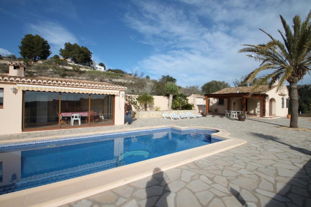 a swimming pool in front of a house at Santa Ana - pretty holiday property with garden and private pool in Benissa in Benissa