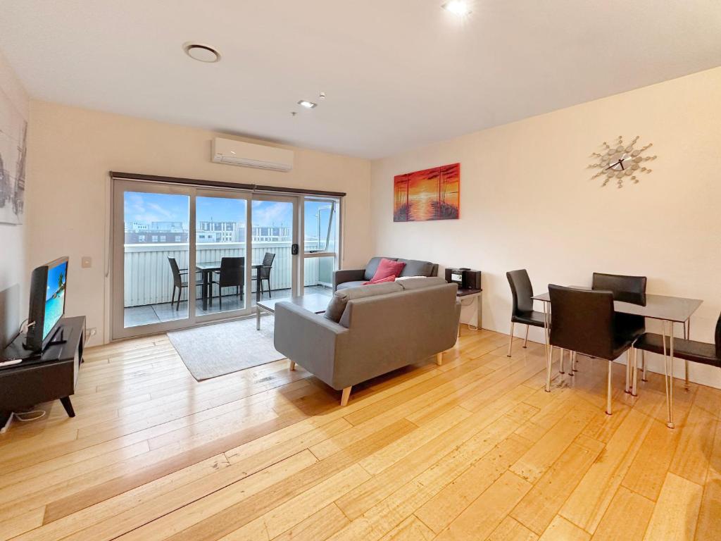 een woonkamer met een bank en een tafel bij The Landings Parnell in Auckland