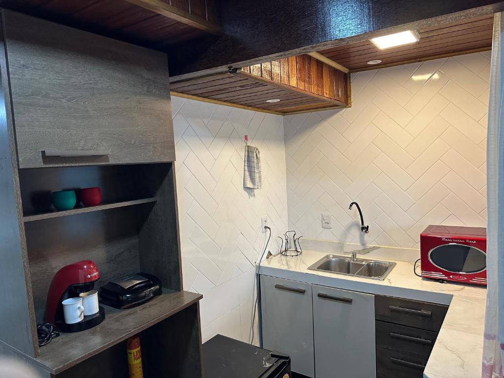 a small kitchen with a sink and a microwave at Moradas Desterro, próximo ao aeroporto 03 in Florianópolis