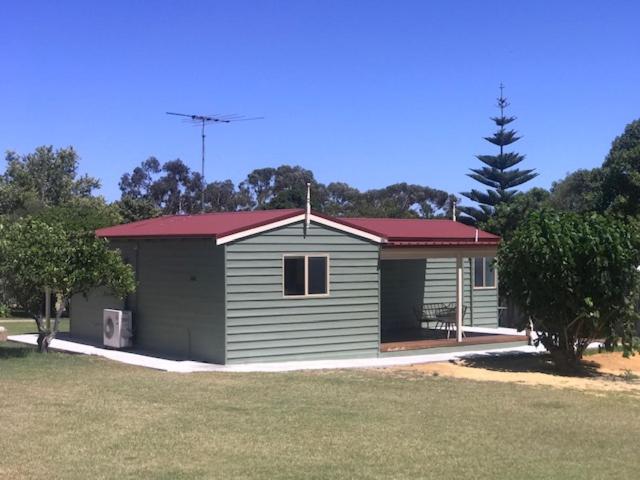 a small house with a red roof in a yard at MULBERRY LODGE in Woodridge