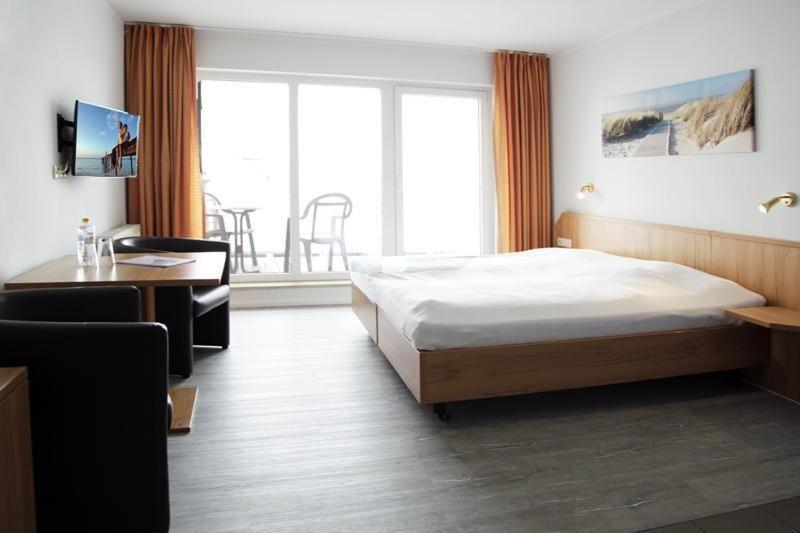 Schlafzimmer mit einem Bett, einem Schreibtisch und einem Fenster in der Unterkunft Yachthafenresidenz - Wohnung 9304 / 888 in Kühlungsborn
