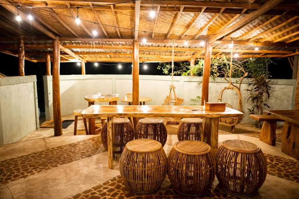 a patio with a table and stools in a room at Rinjani Lighthouse in Senaru