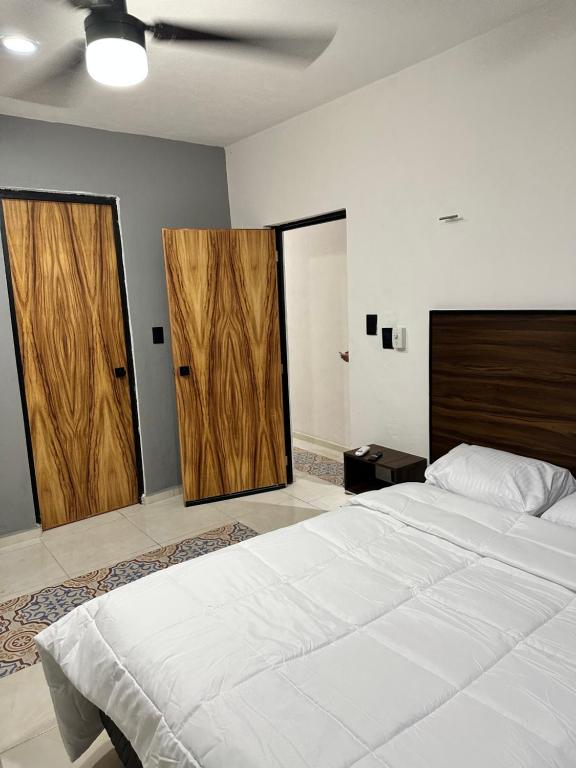 1 dormitorio con 1 cama grande y 2 puertas de madera en Apartamentos 31 en Progreso