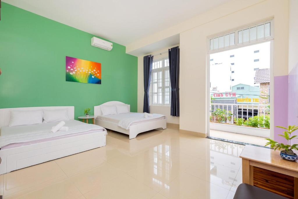 a living room with two beds and a green wall at Lavie House số 124-4 Bình Giã in Vung Tau