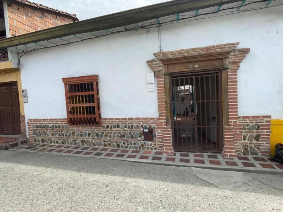 um edifício de tijolos com uma porta e uma janela em Hermoso apartamento Colonial em Santa Fe de Antioquia