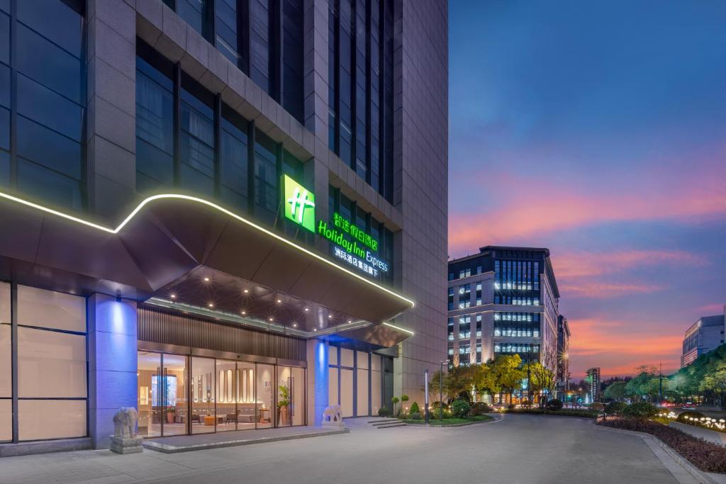 a building with a lit up sign on it at Holiday Inn Express Shanghai Hongqiao Linkong, an IHG Hotel in Shanghai