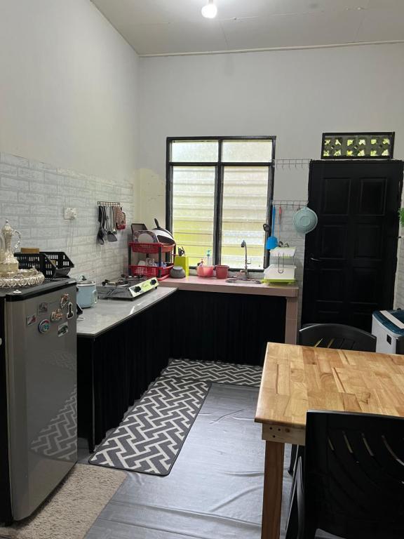 a kitchen with a stove and a sink and a table at cfd homestay in dungun in Dungun