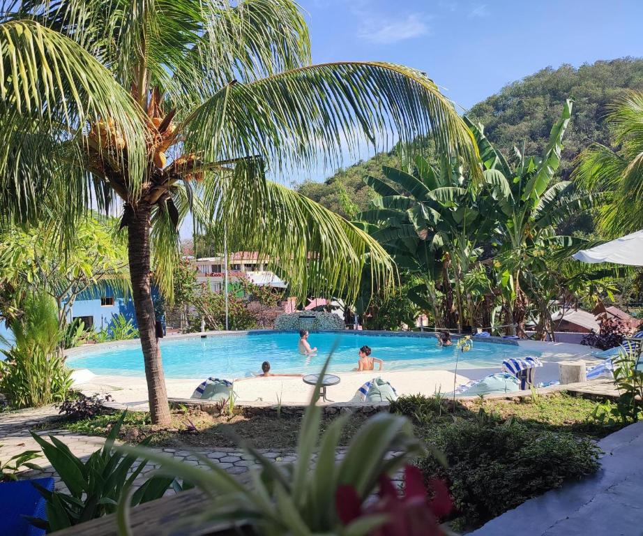 a swimming pool with people in a resort at Wae Molas Hotel in Labuan Bajo