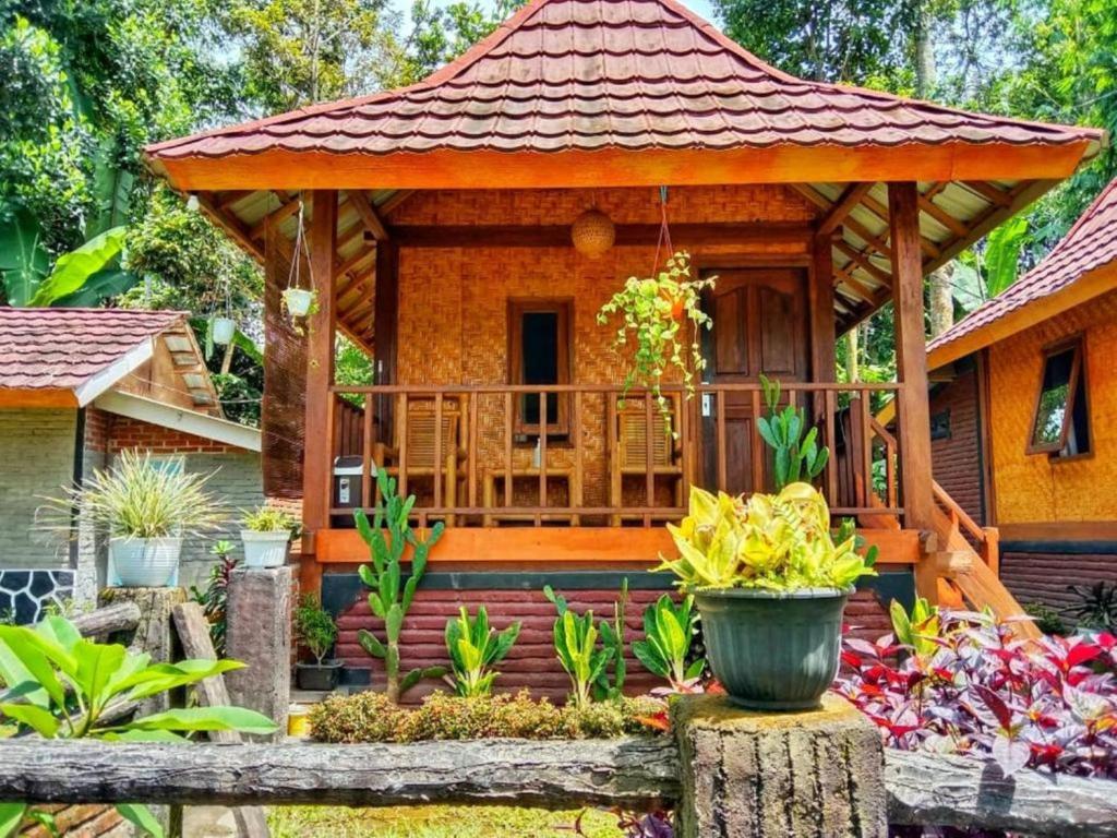 Pondok rinjani bungalow tetebatu في تيتيباتو: منزل صغير مع شرفة