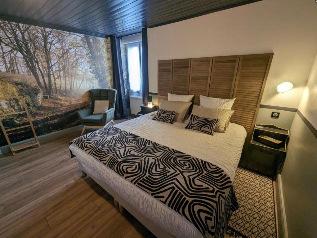 sypialnia z dużym łóżkiem i kocem z odciskiem zebry w obiekcie Le Champ des Sources w mieście Langres