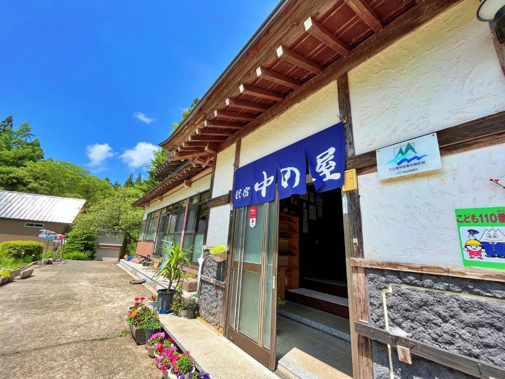 a building with a blue sign on the side of it at Nakanoya in Nanto