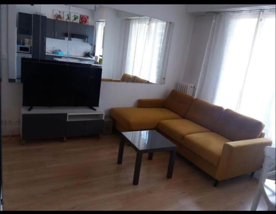 sala de estar con sofá y TV de pantalla plana en En plein coeur de Nice en Niza