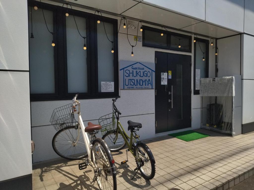 dos bicicletas estacionadas frente a un edificio en セルフチェックイン Guest House SHUKUGO UTSUNOMIYA, en Utsunomiya