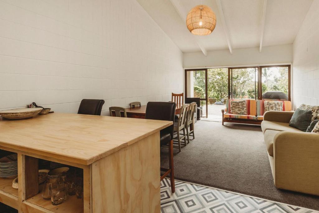 a living room with a table and chairs at The Beach Retreat Sleeps 12 in Oakura