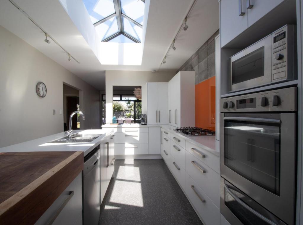 a kitchen with white cabinets and a skylight at Fabulous In Fitzroy Comfortably Sleeps Ten Guests in New Plymouth