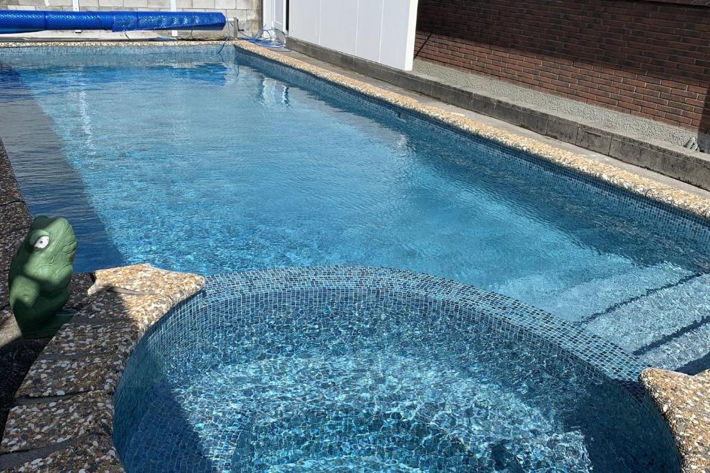 uma piscina com água azul e algumas escadas em Blast On Hine em New Plymouth