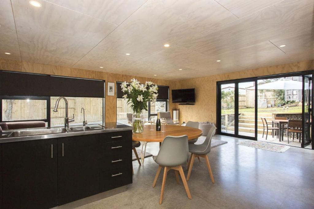 uma cozinha com uma mesa de madeira e uma cozinha com uma sala de jantar em The Natural Home Prime Fitzroy Location em New Plymouth
