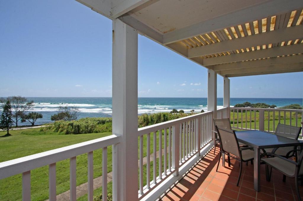 a porch with a table and chairs and the ocean at Quarterdeck 8 in Lennox Head