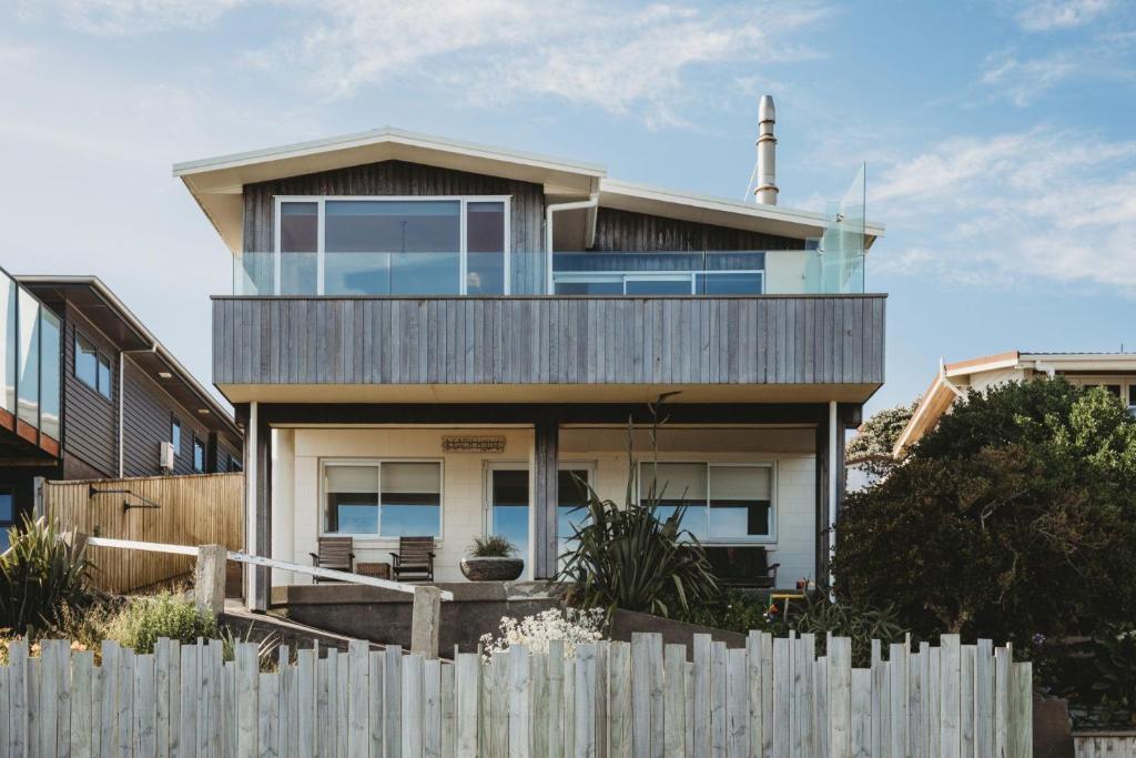 a house with a wooden fence in front of it at Wow On Wanaka Bay in New Plymouth