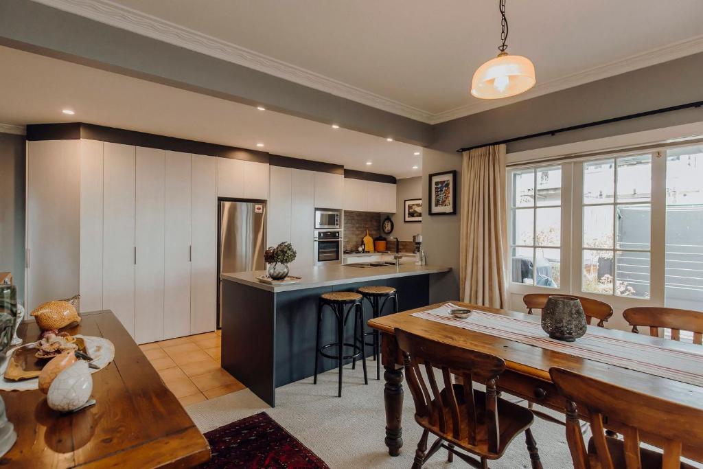 a kitchen and dining room with a wooden table and chairs at The lookout Central in New Plymouth