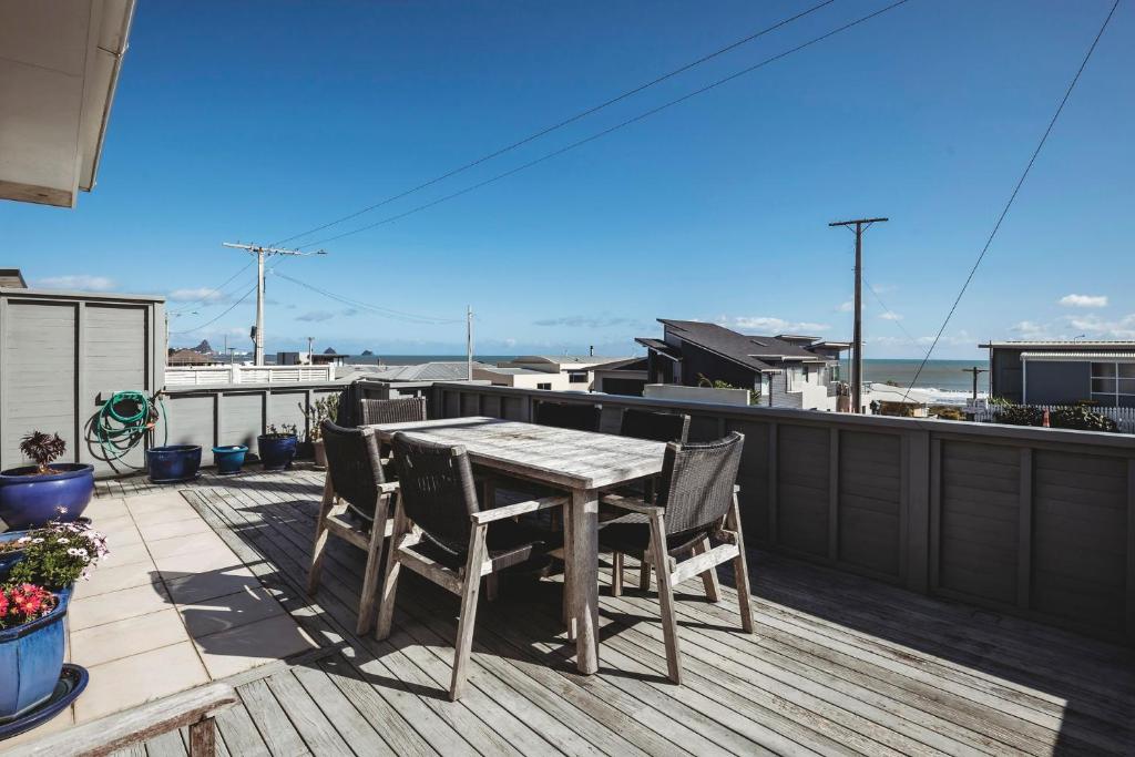 a wooden deck with a table and chairs on a roof at Holiday On Hamblyn in New Plymouth