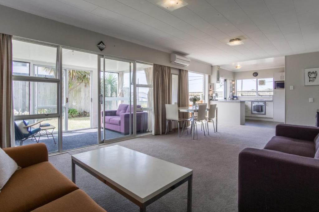 a living room with a couch and a table at Sea Breeze On Belt By Coastal Walkway in New Plymouth