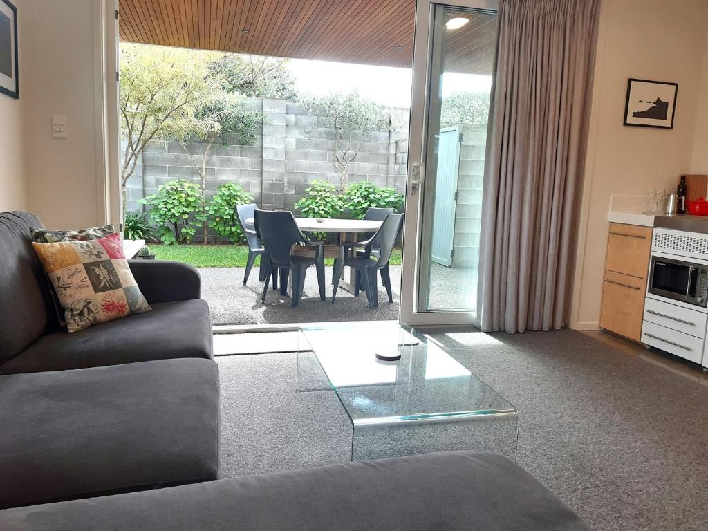 a living room with a couch and a table at By The Sea On Sackville Brand New Apartment in New Plymouth