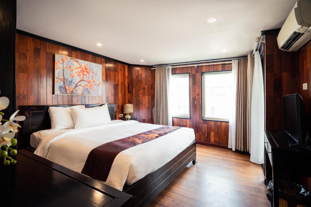 下龍灣的住宿－Dragon Crown Legend Cruise，一间卧室配有一张大床和电视