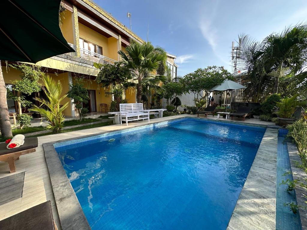 a swimming pool in front of a house at Kelingking Sunset Point Hotel & Spa in Klungkung