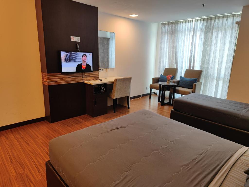 a hotel room with a bed and a flat screen tv at Wan's Studio (Kota Bharu City Point) in Kota Bharu