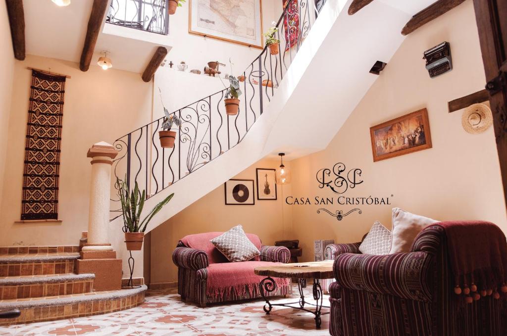 a living room with two couches and a staircase at Casa San Cristóbal in San Cristóbal de Las Casas