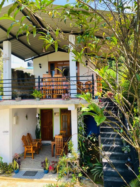 a house with a porch with chairs and tables at Mellow Homestay in Ella
