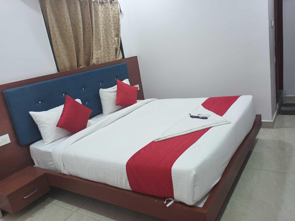 a bedroom with a large bed with red pillows at OYO BRINDAVAN BEACH RESORT & RESTAURANT 