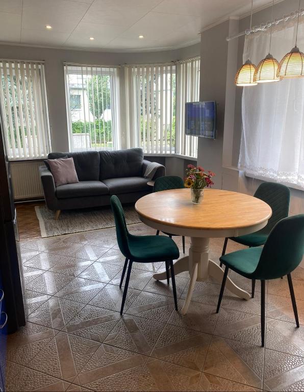 ein Wohnzimmer mit einem Tisch, Stühlen und einem Sofa in der Unterkunft 2 bedroom apartment close to Kaunas airport in Karmelava in Karmėlava