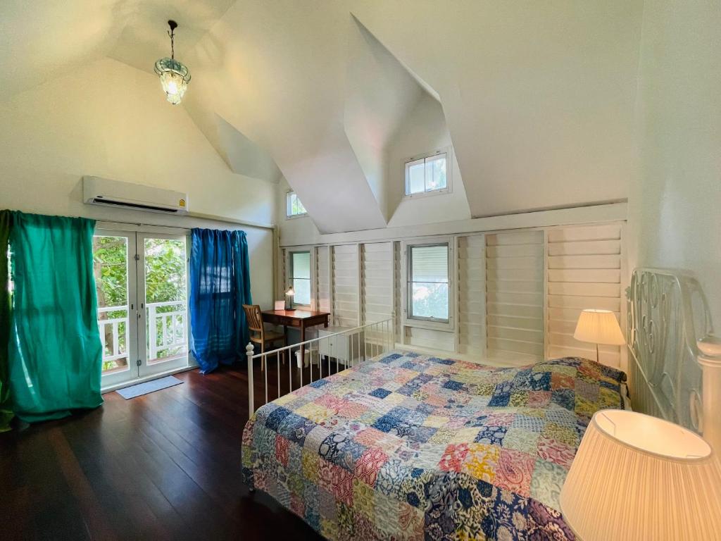 ein Schlafzimmer mit einem Bett in einem Zimmer mit Fenstern in der Unterkunft The Backyard 28 in Klong Toi