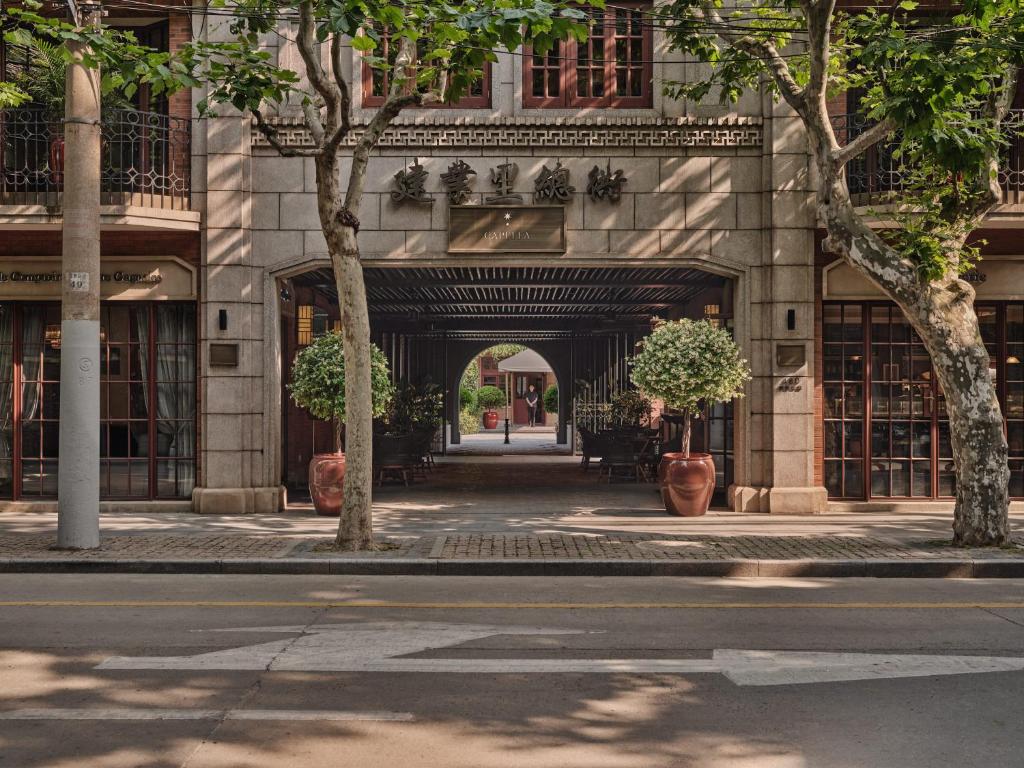 上海的住宿－上海建業裡嘉佩樂酒店，人行道上树木林立的建筑入口
