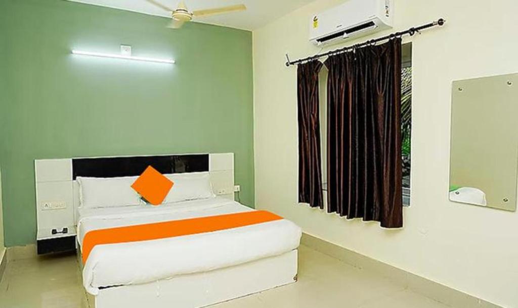 a bedroom with a bed and a window at FabHotel Ekamra Greens By Y Hotels in Bhubaneshwar