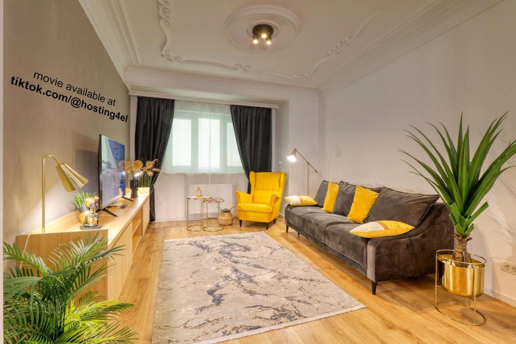 een woonkamer met een bank en een gele stoel bij Historical Center by 4EL in Boekarest