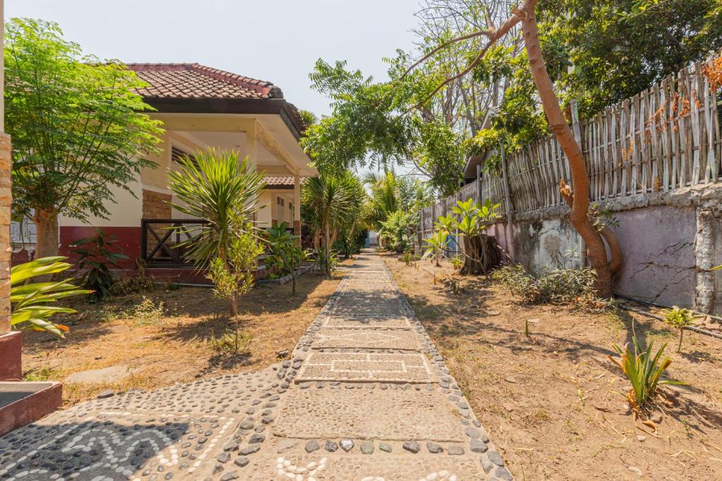 a cobblestone path in front of a house at Funny homestay 2 in Gili Trawangan