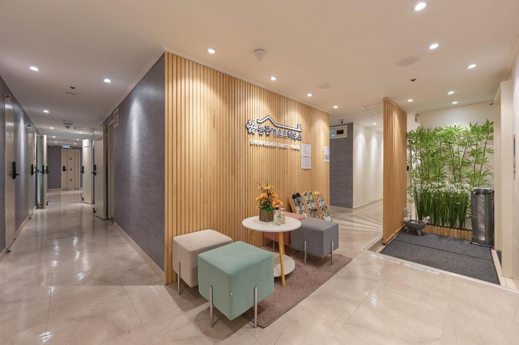 a lobby with a table and chairs and plants at Snowflower Guesthouse in Seoul